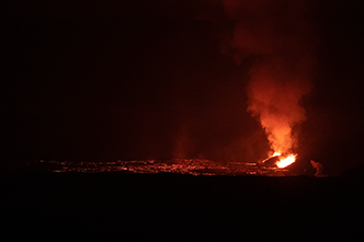 Night-time view of the eruption and pool of lava in Halemaumau Crater as seen from the Crater Rim Trail (after dark).